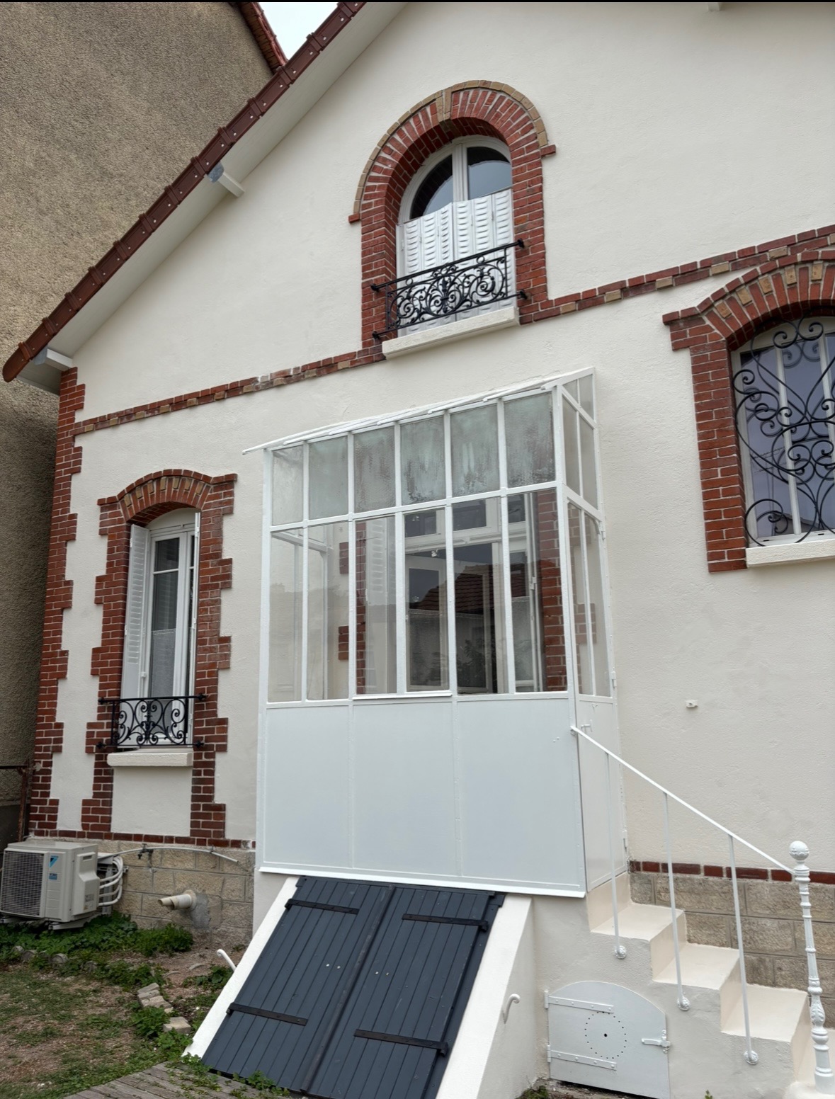 Maison avec véranda après ravalement - façade restaurée et embellie